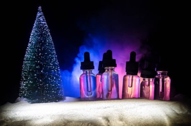 Vape sıvılar ve bokeh ışıklar arka plan üzerinde Noel süslemeleri ile elektronik sigara