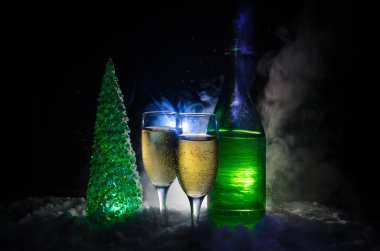 Flüt çifti ve şişe şampanya ile kar koyu arka plan üzerinde Noel ağacına yılbaşı kutlama arka plan.