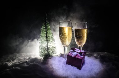 Flüt çifti ve şişe şampanya ile kar koyu arka plan üzerinde Noel ağacına yılbaşı kutlama arka plan.