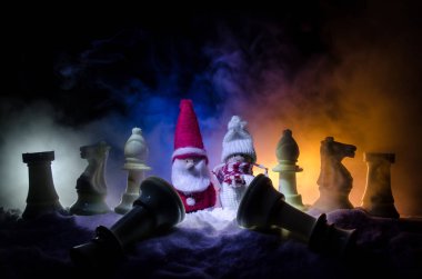 Satranç karda. Kış konsepti. Noel ve yeni yıl bir satranç tahtası üzerinde mevcut karanlık bir arka plan üzerinde Noel Baba ile. Kopya alanı.