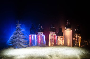 Vape sıvılar ve bokeh ışıklar arka plan üzerinde Noel süslemeleri ile elektronik sigara