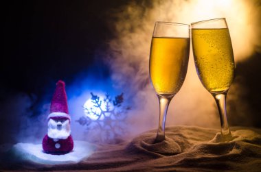 Yılbaşı kutlama ve arka plan flüt çifti şişe şampanya ile karlı koyu tonda sisli arka plan üzerinde Noel öznitelik (veya öğe). Seçici odak.