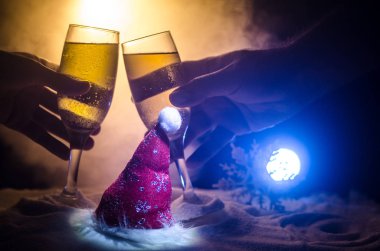 Yılbaşı kutlama ve arka plan flüt çifti şişe şampanya ile karlı koyu tonda sisli arka plan üzerinde Noel öznitelik (veya öğe). Seçici odak.