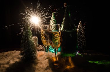 Flüt çifti ve şişe şampanya ile kar koyu arka plan üzerinde Noel ağacına yılbaşı kutlama arka plan.