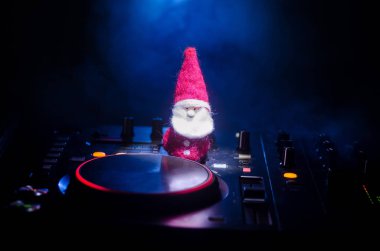 Dj mikser yılbaşı ağacı yılbaşı karanlık gece kulübü zemin üzerine kulaklıklarla. Yeni yıl öğelerinin veya sembolleri (Noel Baba, kardan adam, köpek 2018, hediye kutusu) görünümü bir Dj tabloyu kapatın. tonda