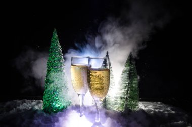 Flüt çifti ve şişe şampanya ile kar koyu arka plan üzerinde Noel ağacına yılbaşı kutlama arka plan.