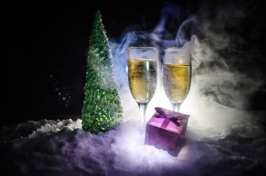 Flüt çifti ve şişe şampanya ile kar koyu arka plan üzerinde Noel ağacına yılbaşı kutlama arka plan.