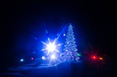 Noel arka plan karlı köknar ağaçları ile. Kar kaplı Noel ağacı parlak bu karla kaplı sahne karanlık mavi tonları karşı çıkmaktadır.