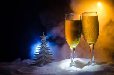 Yılbaşı kutlama ve arka plan flüt çifti şişe şampanya ile karlı koyu tonda sisli arka plan üzerinde Noel öznitelik (veya öğe). Seçici odak.