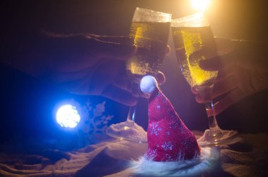 Yılbaşı kutlama ve arka plan flüt çifti şişe şampanya ile karlı koyu tonda sisli arka plan üzerinde Noel öznitelik (veya öğe). Seçici odak.