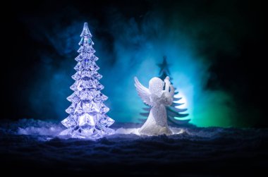 Noel meleği cam xmas şekil ve cam köknar ağacı, yılbaşı ağacı, koyu arka plan üzerinde docorative öğeleri. Noel dekorasyon melek xmas kavramı. Seçici odak