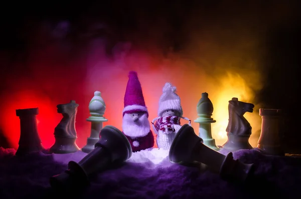 Schaken in de sneeuw. winter concept. Kerstmis of Nieuwjaar op een schaakbord aanwezig met de kerstman op een donkere achtergrond. Kopiëren van ruimte. — Stockfoto