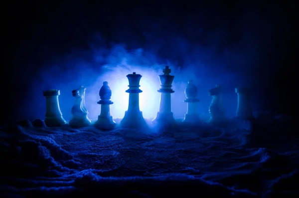 Schach im Schnee. Winterkonzept. Weihnachts- oder Neujahrsgeschenk auf einem Schachbrett mit Weihnachtsmann auf dunklem Hintergrund. Kopierraum. — Stockfoto