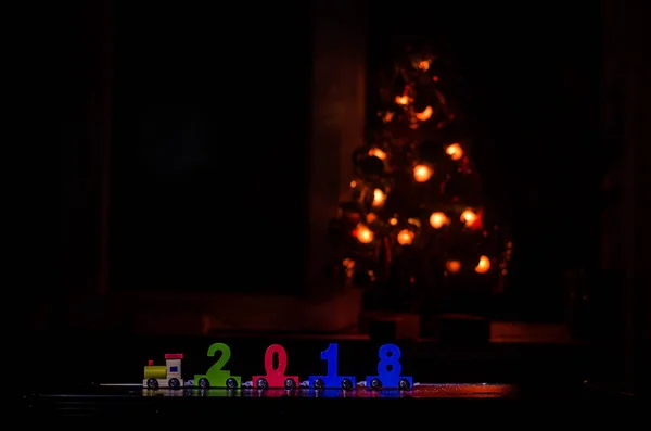 2018 feliz año nuevo, tren de juguete de madera que lleva números de 2018 año en la nieve. Tren de juguete con 2018. Copiar espacio. Decoración de Navidad. Enfoque selectivo — Foto de Stock