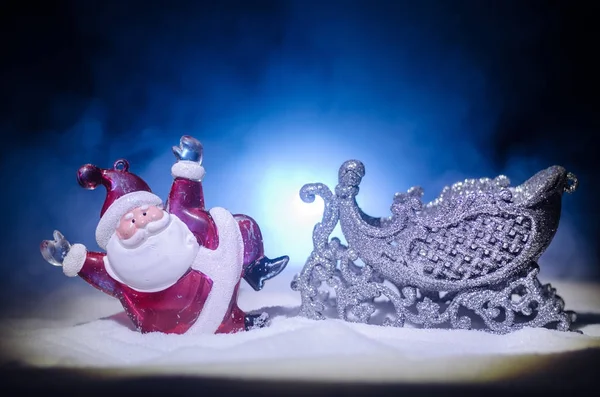 Happy Santa Claus Doll op Kersttijd met boom en sneeuw. Kleurrijke bokeh achtergrond. Kerstman en Merry Christmas model figuur speelgoed op donker getinte mistige achtergrond. — Stockfoto