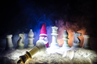 Satranç karda. Kış konsepti. Noel ve yeni yıl bir satranç tahtası üzerinde mevcut karanlık bir arka plan üzerinde Noel Baba ile. Uzay kopyalayın. Seçici odak