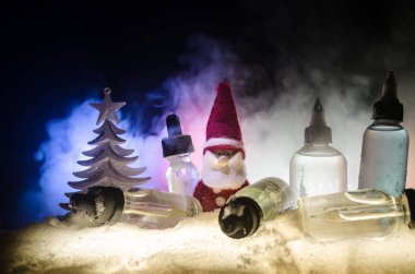 Elektronik sigara vape sıvılar ve Noel süsleri yılbaşı özellikleri veya semboller bokeh ışıklar zemin üzerine. Seçici odak