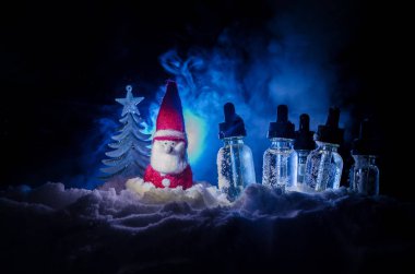 Elektronik sigara vape sıvılar ve Noel süsleri yılbaşı özellikleri veya semboller bokeh ışıklar zemin üzerine. Seçici odak
