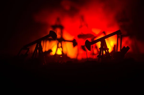 Bomba de aceite equipo industrial de energía para petróleo, plataformas petrolíferas del grupo y sitio industrial brillantemente iluminado por la noche. Toned.Background para el diseño . — Foto de Stock