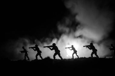 Karanlık sisli gökyüzü zemin karşı askerlerin askeri siluetleri. Patlama ve yanma bulutların arkasına fighing askerler ile savaş sahnesi. Oyuncak dekorasyon