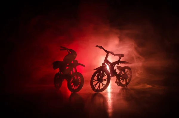 在黑暗的多云色调背景下, 摩托车和自行车的剪影。从侧面看摩托车和自行车的剪影。选择性焦点 — 图库照片