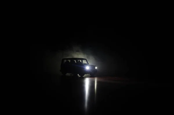 Sylwetka samochodu w nocy. Scena z ciemnym tle światła i dymu. — Zdjęcie stockowe
