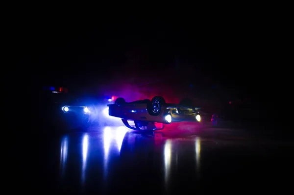 Rendőrautó üldöz egy kocsit éjszaka, ködös háttérrel. 911 Sürgősségi segélyhívó rendőrautó száguld a tetthelyre. — Stock Fotó
