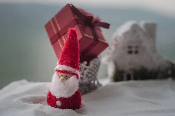 Caja de regalo roja de Navidad y abeto en la nieve. Decoración de la casa de Navidad con nieve y árbol sobre fondo borroso durante el día con espacio para copiar. Enfoque selectivo . — Foto de Stock