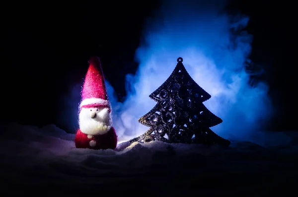 Счастливого Санта-Клауса на Рождество с елкой и снегом. Красочный боке фон. Дед Мороз и Весёлая рождественская игрушка на темном туманном фоне — стоковое фото