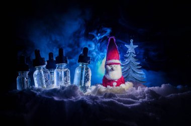 Vape sıvılar ve bokeh ışıklar arka plan üzerinde Noel süslemeleri ile elektronik sigara