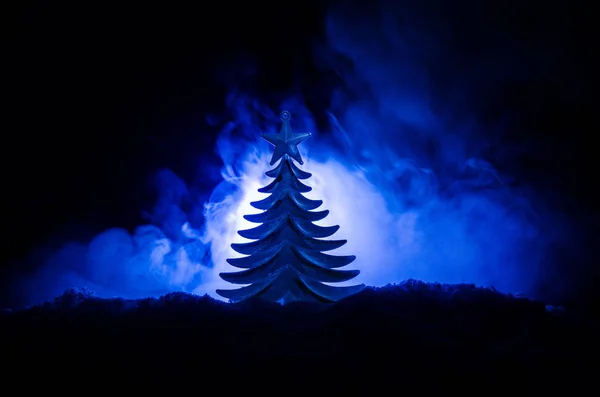 Рождественский фон со снежными елками. Заснеженная рождественская елка ярко выделяется на фоне темно-синих тонов этой заснеженной сцены . — стоковое фото