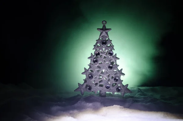 Karácsonyi háttér havas fenyő. Hó borított karácsonyfa áll fényesen szemben a sötét kék (vagy zöld) hangok a hóval borított táj. Tónusú sötét háttér — Stock Fotó