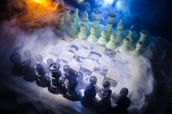 雪の中でチェス。冬のコンセプトです。クリスマスや新年は暗い背景にサンタ クロースとチェス盤の上に存在します。コピー スペース. — ストック写真
