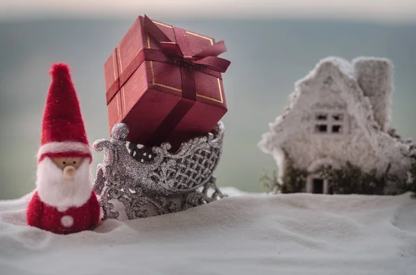 Caixa de presente de Natal vermelho e abeto na neve. Decoração de casa de Natal com neve e árvore no fundo borrado durante o dia com espaço de cópia. Foco seletivo . — Fotografia de Stock