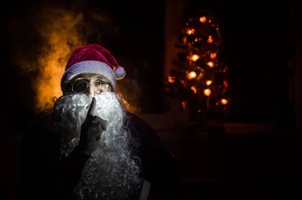 Santa Claus patrząc w kamerę z tradycyjnych tło. Mikołaj przyniósł prezenty na Boże Narodzenie i po odpoczynku. Selektywny fokus — Zdjęcie stockowe
