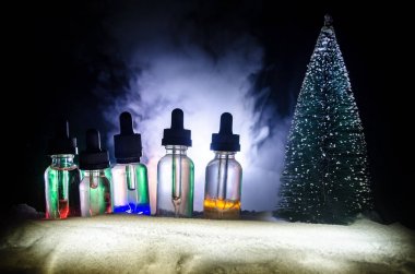 Elektronik sigara vape sıvılar ve Noel süsleri yılbaşı özellikleri veya semboller bokeh ışıklar zemin üzerine. Seçici odak