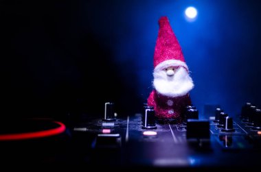 Dj mikser yılbaşı ağacı yılbaşı karanlık gece kulübü zemin üzerine kulaklıklarla. Dj masaya kadar yeni yıl öğelerinin veya sembolleri (Noel Baba, kardan adam, köpek 2018, hediye kutusu) Görünümü Kapat.