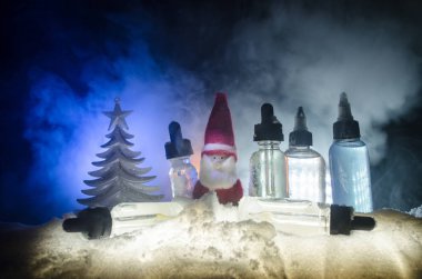 Elektronik sigara vape sıvılar ve Noel süsleri yılbaşı özellikleri veya semboller bokeh ışıklar zemin üzerine. Seçici odak