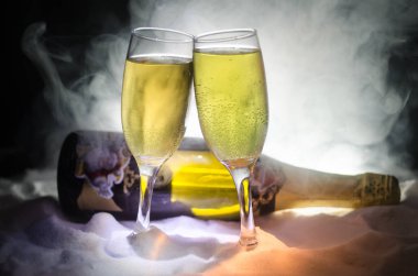 Yılbaşı kutlama ve arka plan flüt çifti şişe şampanya ile karlı koyu tonda sisli arka plan üzerinde Noel öznitelik (veya öğe). Seçici odak. Tebrik kartı olarak yararlı