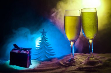 Yılbaşı kutlama ve arka plan flüt çifti şişe şampanya ile karlı koyu tonda sisli arka plan üzerinde Noel öznitelik (veya öğe). Seçici odak. Tebrik kartı olarak yararlı