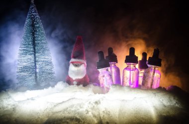 Elektronik sigara vape sıvılar ve Noel süsleri yılbaşı özellikleri veya semboller bokeh ışıklar zemin üzerine. Seçici odak