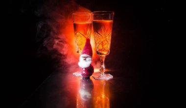Yılbaşı kutlama ve arka plan flüt çifti şişe şampanya ile karlı koyu tonda sisli arka plan üzerinde Noel öznitelik (veya öğe). Seçici odak.