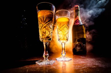 Yılbaşı kutlama ve arka plan flüt çifti şişe şampanya ile karlı koyu tonda sisli arka plan üzerinde Noel öznitelik (veya öğe). Seçici odak. Tebrik kartı olarak yararlı