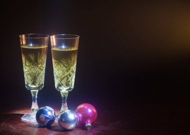 Yılbaşı kutlama ve arka plan flüt çifti şişe şampanya ile karlı koyu tonda sisli arka plan üzerinde Noel öznitelik (veya öğe). Seçici odak. Tebrik kartı olarak yararlı