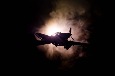 World war ii fighter plane at sunset or dark orange fire explosion sky. War scene. German figher at sky clipart