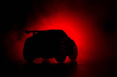 Gölgelerin içinde araba ile düşük ışık veya spor araba koyu arka plan silüeti parlayan ışıklar.