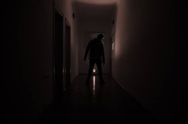 Kabine kapılar ve korkunç korku adam ile farklı pozlar ayakta silüeti ışıklarla karanlık koridor.