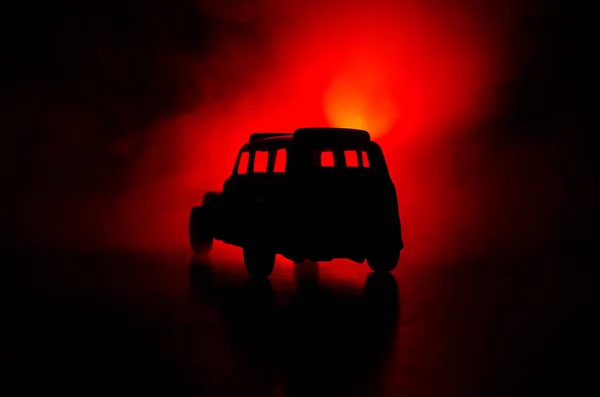 Bilen i skuggorna med glödande lampor i svagt ljus eller silhuetten av sport bil mörk bakgrund. — Stockfoto