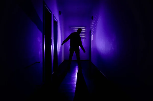 キャビネットの扉や不気味なホラーに異なるポーズで立っている男のシルエットが付いているライトで暗い廊下. — ストック写真