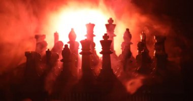 Satranç oyununu kavramı iş fikirleri ve rekabet ve strateji fikirler kavramı. Satranç figürleri duman ve sis karanlık bir arka plan üzerinde. Seçici odak